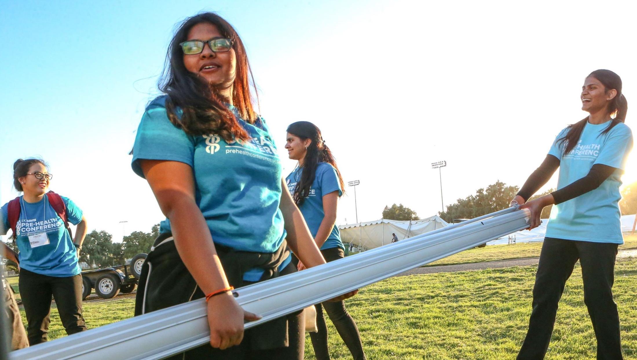 3 Conference volunteers on hutchison field. join the team today