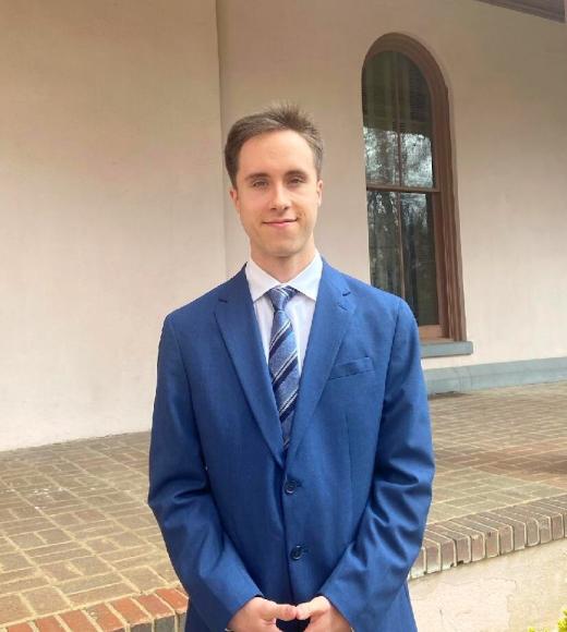 Man with a blue suit standing in front of a building