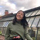Megan smiling with a green house in the background